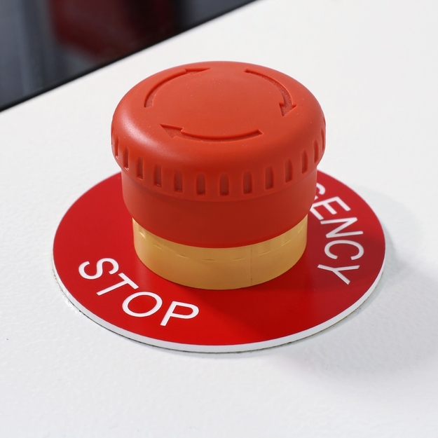 Red/white circular e-stop label installed on e-stop button
