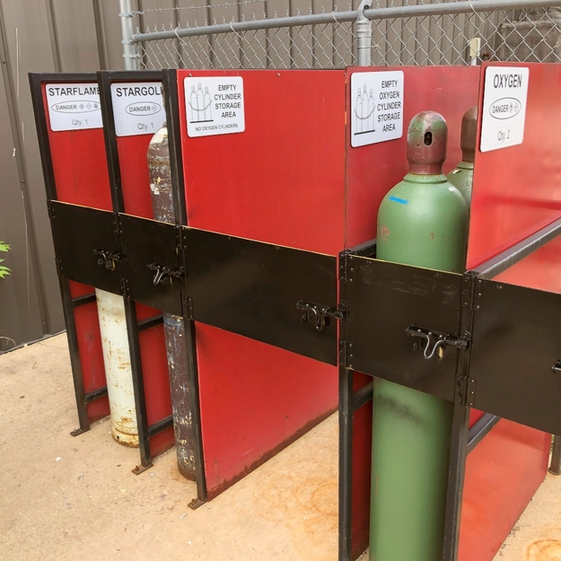 Gas cylinder storage area, labeled with black/white signage